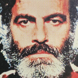 Może przedstawiać: Zbliżenie twarzy mężczyzny z brodą i wąsami. Jego oczy patrzą prosto w kamerę. Obraz jest w stylu vintage.