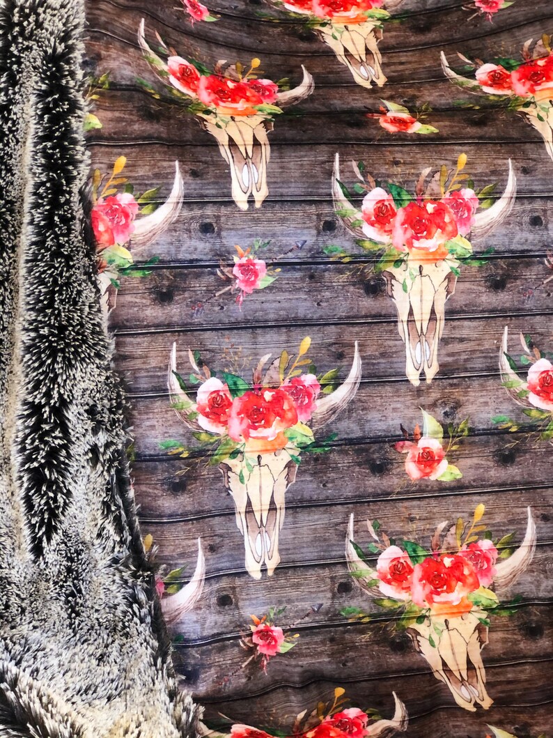 May include: A brown wooden background with a repeating pattern of white skull designs with red and pink floral accents.