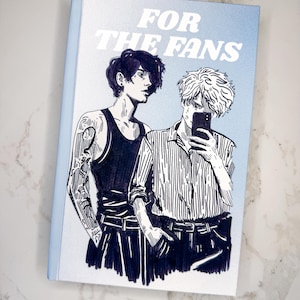 Può includere: Una copertina di un libro con uno sfondo sfumato blu e bianco. La copertina presenta un'illustrazione in bianco e nero di due persone, una con i capelli corti e l'altra con i capelli lunghi. Il testo "FOR THE FANS" è stampato in bianco sulla copertina.