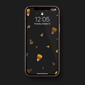 May include: A black iPhone screen with a candy corn pattern and the time 12:05 displayed. The date is Thursday, October 21.