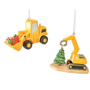 May include: Two yellow construction vehicle Christmas ornaments. One is a front loader with a pile of wrapped presents in the bucket. The other is a crane lifting a small green Christmas tree.