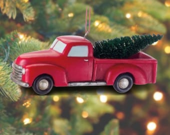 Könnte beinhalten: Roter Vintage-Pickup-Truck-Weihnachtsbaumschmuck mit einem kleinen grünen Weihnachtsbaum in der Ladefläche.