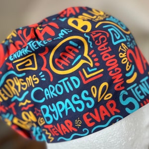 Könnte beinhalten: Eine blaue OP-Mütze mit einem bunten Druck von medizinischen Begriffen, darunter "AAA", "Aneurysmen", "Bypass", "Carotis", "Stent" und "TEVAR vs."