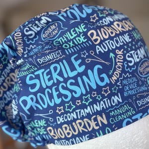 Peut inclure: Un bonnet de chirurgien bleu marine avec des termes médicaux répétés en blanc, bleu clair et sarcelle. Les mots "STERILE PROCESSING", "BIOBURDEN", "STEAM" et "DISINFECT" sont mis en évidence.