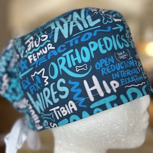 May include: Blue and white surgical scrub hat with a pattern of medical terms and phrases, including "Orthopedics", "Open Reduction", "Internal Fixation", and "Take a Break".