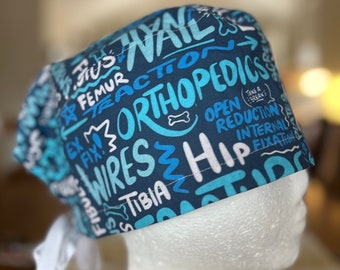 May include: Blue and white surgical scrub hat with a pattern of medical terms and phrases, including "Orthopedics", "Open Reduction", "Internal Fixation", and "Take a Break".