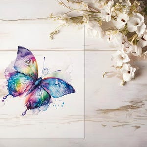 Könnte beinhalten: Ein Aquarellgemälde eines Schmetterlings in leuchtenden Farben, darunter Blau, Lila, Grün und Gelb. Der Schmetterling ist mit ausgebreiteten Flügeln dargestellt, vor einem weißen Hintergrund mit Holzmaserung. Weiße Blumen sind im Hintergrund.
