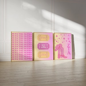 May include: Three framed prints with a pink and yellow color scheme. The first print features the text "ZETA TAU ALPHA" repeated multiple times. The second print features a ticket with the text "ZETA TAU ALPHA" and the abbreviation "ZTA". The third print features a pair of pink cowboy boots with a cowboy hat and the text "ZTA".