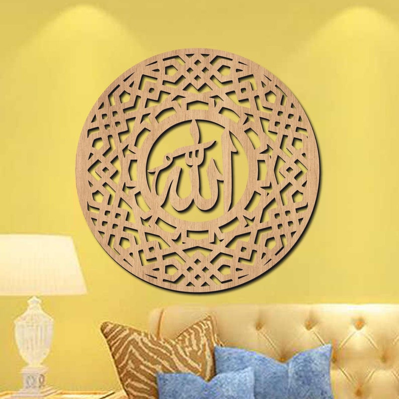 Pu&ograve; includere: Un decoro da parete in legno con un intricato motivo geometrico e la parola araba "Allah" al centro. Il decoro &egrave; di colore marrone chiaro e ha una forma circolare.