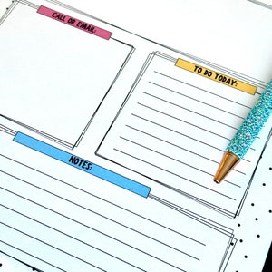 May include: A white planner with black lines and black polka dots. The planner has sections for reminders, to do today, call or email, and notes. The planner has a blue, yellow, and pink colored title.