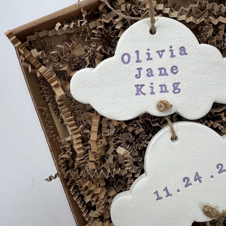 personalised Clay cloud wall hanging keepsake decoration ornament. three clouds attached to each other with twine for nursery wall art. First cloud has baby’s name, middle cloud baby weight and third cloud birth date. handpainted in choice of colour