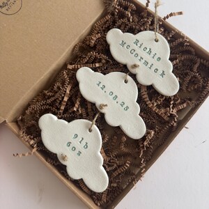 personalised Clay cloud wall hanging keepsake decoration ornament. three clouds attached to each other with twine for nursery wall art. First cloud has baby’s name, middle cloud baby weight and third cloud birth date. handpainted in choice of colour
