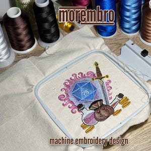 May include: Machine embroidery design featuring a blue 20-sided die, a sword, and two potion bottles. The design is surrounded by a pink and purple flame-like pattern. The design is on a white fabric.