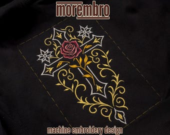 May include: Black fabric with an embroidered design featuring a cross, rose, and floral elements in white, gold, and pink. The text "morembro" is at the top, and "machine embroidery design" is at the bottom.