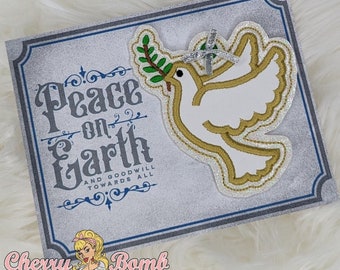 May include: A decorative sign with the words "Peace on Earth" in grey script. A white dove with a gold outline and olive branch is on the right. The sign has a silver glitter background and a blue border.