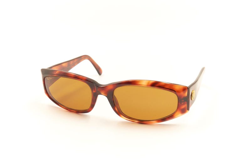 May include: Tortoise shell sunglasses with brown lenses. The sunglasses have a classic, retro style.