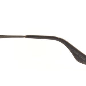 Pu&ograve; includere: Primo piano di un'asta di occhiali Ray-Ban grigio scuro. Il testo "B & L RAY-BAN" &egrave; stampato sull'asta. L'asta si curva verso il basso e termina con una punta arrotondata.