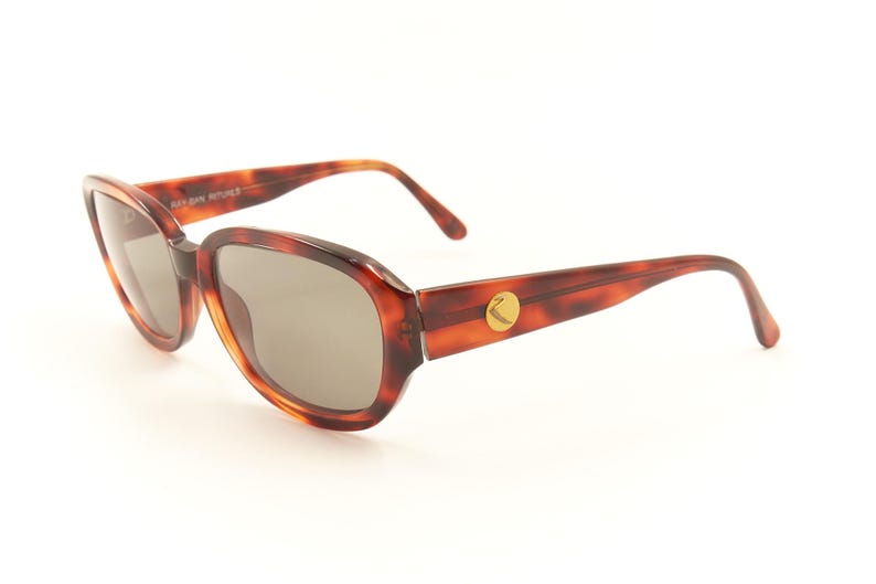 May include: Tortoise shell sunglasses with brown lenses and a gold logo on the side.