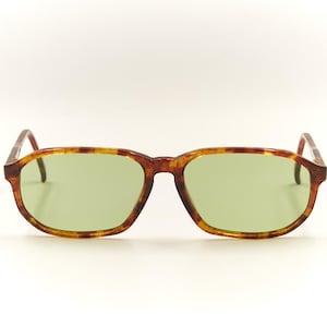 May include: A pair of tortoise shell sunglasses with green lenses.