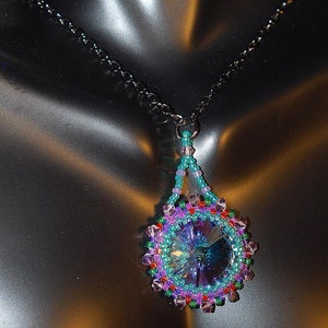 May include: A silver chain necklace with a beaded pendant featuring a large iridescent blue crystal surrounded by smaller purple, green, and pink beads.