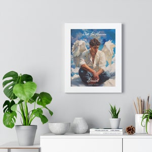 May include: A framed print of a man with angel wings sitting on clouds. The print has the text "Rest In Heaven" and "Daniel 1993-2021".
