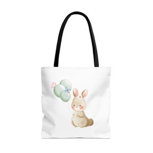 May include: White tote bag with black handles featuring a watercolor illustration of a brown bunny holding green and blue balloons with a pink and blue butterfly.