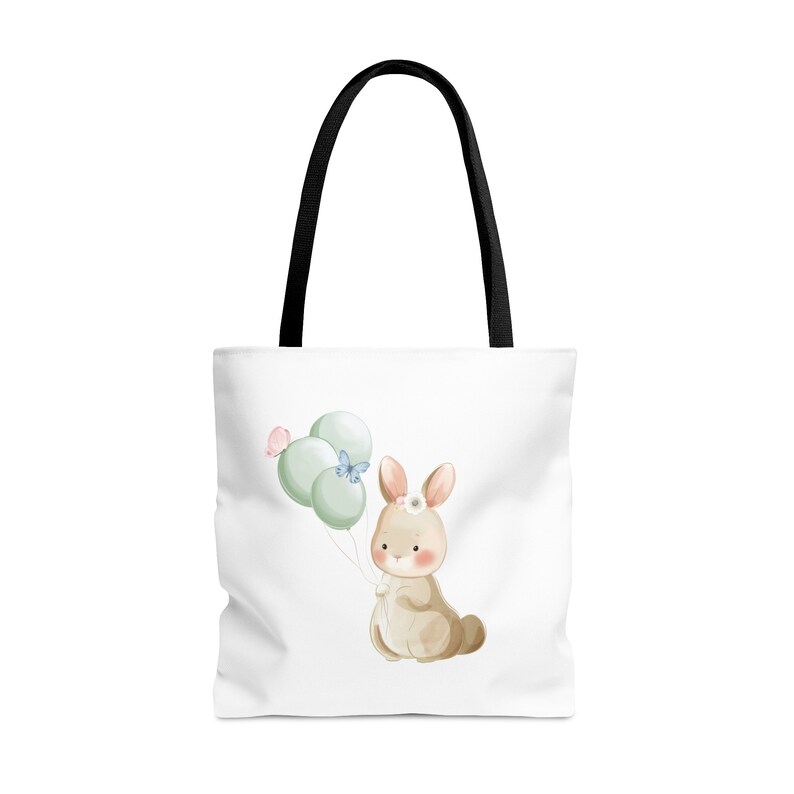 May include: White tote bag with black handles featuring a watercolor illustration of a brown bunny holding green and blue balloons with a pink and blue butterfly.
