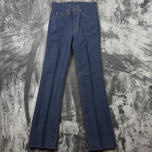 Può includere: Un paio di jeans in denim blu scuro con vita alta, chiusura frontale con bottone e classico design a cinque tasche. I pantaloni presentano un taglio a gamba dritta con un leggero svaso sul fondo e pieghe verticali visibili su ogni gamba.