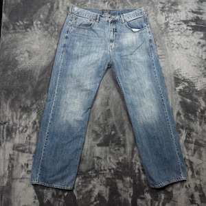 May include: A pair of light blue denim jeans featuring a classic five-pocket design, a button fly closure, and a faded wash finish. The jeans have a straight-leg cut with visible stitching along the seams, belt loops at the waist, and metal rivets.