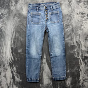 May include: Light blue denim jeans featuring a high-waisted design with a vertical row of five metallic buttons. The pants include two square patch pockets on the front, belt loops at the waistband, and straight-cut legs with finished hems.
