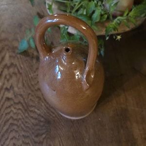 Brocca con beccuccio a puzzle in terracotta rossa, stile arte popolare contemporanea, realizzata a mano, ceramica primitiva in stile americano antico.