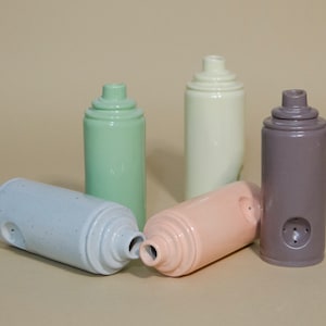 May include: Five ceramic spray paint can shaped vases in different colors. The vases are light blue, light green, light pink, cream, and gray.