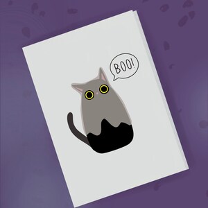 May include: A white card with a gray cat with black ears and a black tail. The cat has large yellow eyes and is saying "BOO!" in a speech bubble.