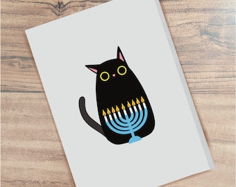 May include: A black cat with yellow eyes sits in front of a blue menorah with lit candles. The menorah has nine candles, and the cat is looking at the viewer.