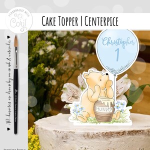 May include: Winnie the Pooh cake topper with a blue balloon that says "Christopher 1" and a honey pot that says "Hunky".