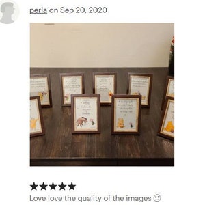 May include: A set of eight small, brown picture frames with Winnie the Pooh and Piglet illustrations. Each frame has a different quote about friendship and love. The frames are arranged on a dark brown wooden surface.