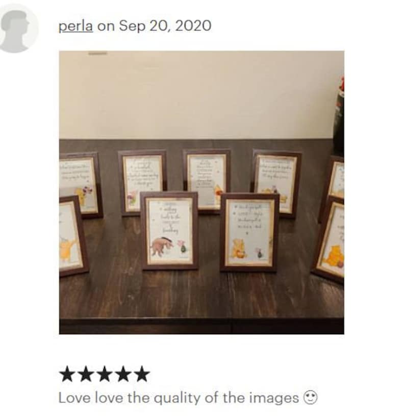 May include: A set of eight small, brown picture frames with Winnie the Pooh and Piglet illustrations. Each frame has a different quote about friendship and love. The frames are arranged on a dark brown wooden surface.