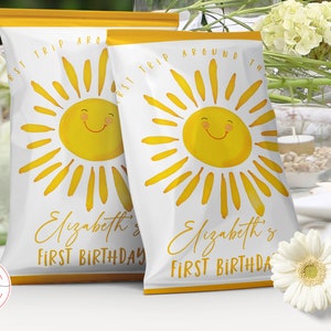 May include: Two white chip bags with a yellow border. Each bag features a yellow sun with a smiling face and the text "First Trip Around The Sun" and "Elizabeth's First Birthday".