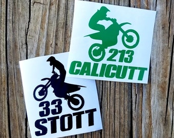 May include: Two motocross decals, one black and one green, with a rider silhouette and racing number. The black decal says "33 STOTT" and the green decal says "213 CALICUTT".