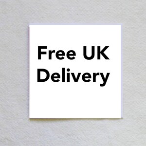 May include: A white square card with the text "Free UK Delivery" in bold black letters. The card is centered and set against a textured, off-white background.