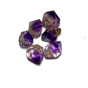 May include: A collection of six raw amethyst crystal points featuring deep purple hues and translucent sections. Each stone displays natural facets, irregular edges, and earthy brown inclusions, showcasing a variety of shapes and sizes.