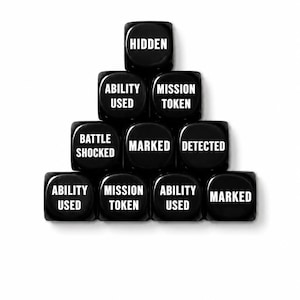 May include: A pyramid arrangement of nine black six-sided dice with white text. The dice are labeled with the following phrases: HIDDEN, ABILITY USED, MISSION TOKEN, BATTLE SHOCKED, MARKED, DETECTED, ABILITY USED, MISSION TOKEN, ABILITY USED, and MARKED.