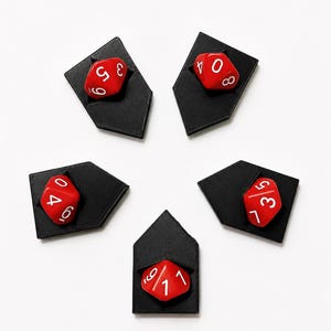 May include: Five red dice with white numbers are displayed in black, geometric holders. The dice are arranged in a circular pattern against a white background. The dice show different numbers, from 0 to 9.