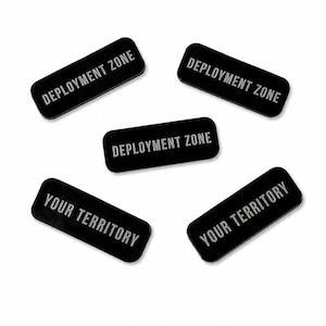 May include: Five rectangular black markers with rounded corners. Three markers feature the white text DEPLOYMENT ZONE, and two markers feature the white text YOUR TERRITORY. The markers are arranged in a scattered pattern on a white background.