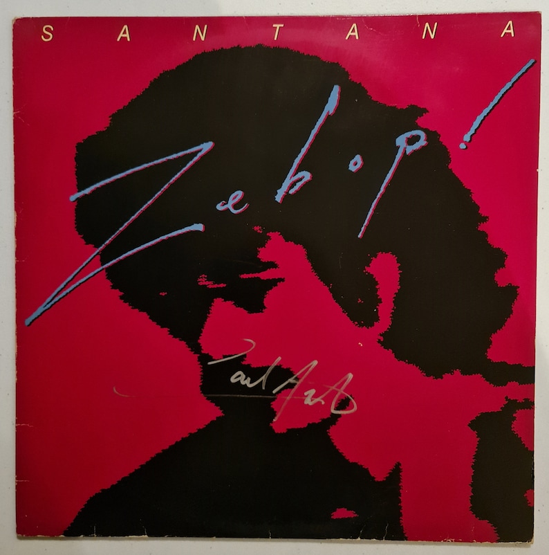 Puede incluir: Una portada de disco de vinilo rojo con el t&iacute;tulo "Zebop!" en letras azules y negras. La portada presenta una silueta negra de la cabeza y los hombros de una persona. El &aacute;lbum es de Santana.