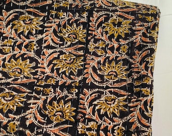 May include: Black fabric with a floral pattern in shades of brown, orange, and white. The fabric is quilted and has a subtle sheen.