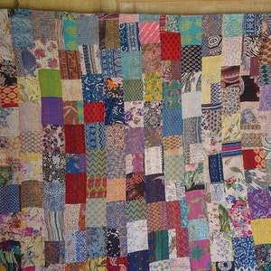 K&ouml;nnte beinhalten: Eine farbenfrohe Patchwork-Decke aus verschiedenen Stoffen. Die Decke besteht aus vielen verschiedenen Quadraten, jedes mit einem einzigartigen Muster. Die Decke ist ein wundersch&ouml;nes Beispiel f&uuml;r traditionelle indische Handwerkskunst.