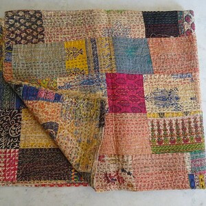 K&ouml;nnte beinhalten: Eine Patchwork-Decke mit einer Vielzahl von Farben und Mustern, darunter florale, geometrische und Paisley-Designs. Die Decke ist aus Baumwollstoff gefertigt und handgen&auml;ht.