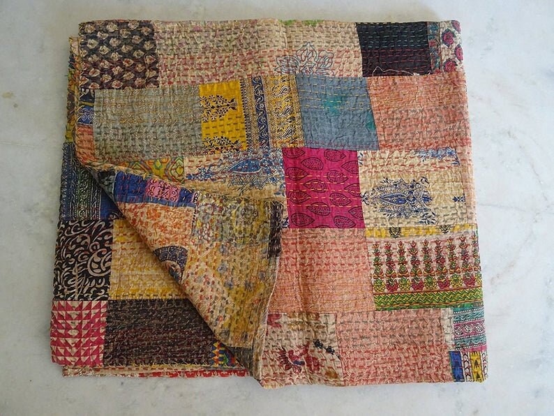 K&ouml;nnte beinhalten: Eine Patchwork-Decke mit einer Vielzahl von Farben und Mustern, darunter florale, geometrische und Paisley-Designs. Die Decke ist aus Baumwollstoff gefertigt und handgen&auml;ht.