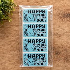 May include: A clear plastic sleeve containing four rectangular light blue stickers. Each sticker features a black line drawing of an envelope surrounded by flowers and the text "HAPPY MAIL THANK YOU" with small heart accents on the sides.